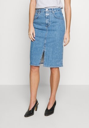 Denim midi-rok in lichtblauw, met een voorste split, vijfzakkenontwerp en een standaard tailleband. Gecombineerd met zwarte hoge hakken.