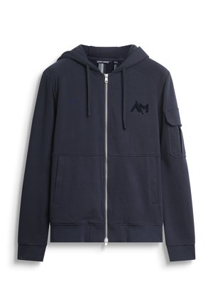 Felpa con zip di colore blu navy realizzata in tessuto morbido, dotata di cappuccio, tasche frontali e una tasca sul braccio sinistro con dettaglio logo nero.