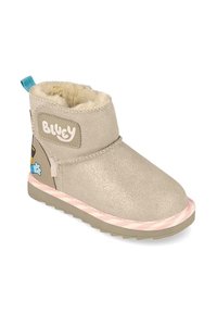 Botín beige de tobillo hecho de material texturizado, con forro de felpa, parche con logo y suela a rayas rosas. Personaje de dibujos animados en el costado.