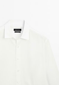 Weiße Button-Down-Bluse mit klassischem Kragen, bestehend aus einem glatten Stoff und transparenten Bereichen an den Schultern, mit Markenetikett innen.