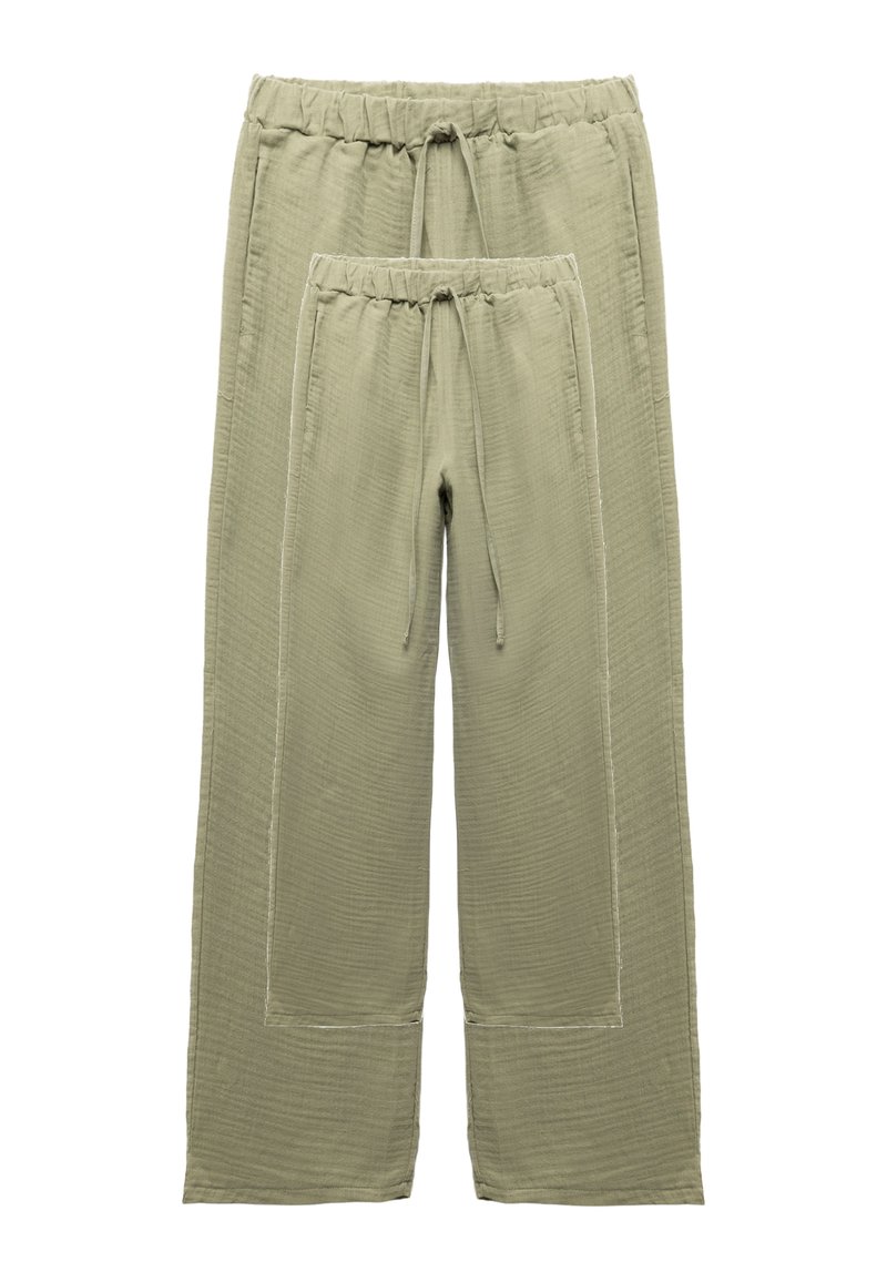 Pantalones verde oliva con una tela texturizada, que cuentan con una cintura elástica y cordón. Incluye un par más pequeño con el mismo diseño.