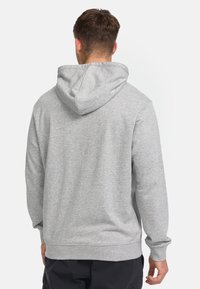 Grå hættetrøje med foret hætte, fremstillet af et blødt, tekstureret stof. Ribbet manchetter og kant fuldender det afslappede fit-design.