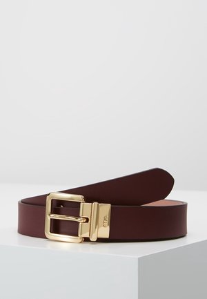 Ceinture en cuir marron foncé avec boucle carrée dorée polie posée sur une surface blanche devant un arrière-plan uni.