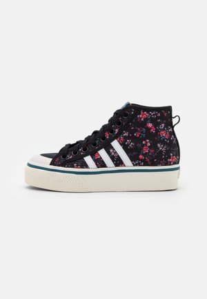 Højtop sort sneakers med hvid gummisål, hvide striber, sorte snørebånd og rødt og pink blomsterprint på stoffets overdel.