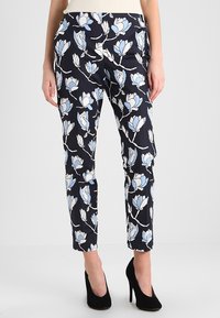 Kalhoty s květinovým potiskem mají námořnické pozadí s bílými a světle modrými motivy magnolie. Slim fit s hladkou texturou látky a délka ke kotníkům.