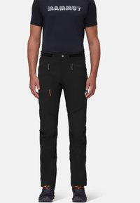 Pantalons extérieurs noirs avec une coupe ajustée, dotés de poches zippées et d'accents en matériel orange contrasté. Tissu durable avec une finition texturée.