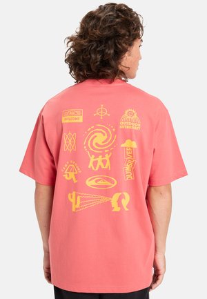 Coral pink t-shirt with short sleeves, featuring yellow graphic prints on the back, including various symbols and patterns.
