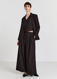 Braun maßgeschneidertes Anzugset mit einer taillierten Blazerjacke mit Knöpfen und weiten Hosen. Glatter Stoff mit strukturierter Passform.