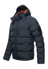 Marineblå pufferjakke med lynlås foran, hætte, orange detaljer og et mærke på ærmet. Har et quilted design og to foran lommer.