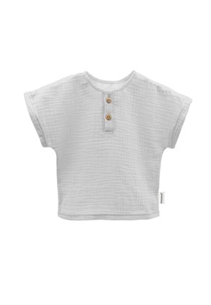 Weißes Baumwolloberteil mit kurzen Ärmeln und strukturiertem Finish, mit Rundhalsausschnitt und zwei Holzknöpfen an der Vorderseite.