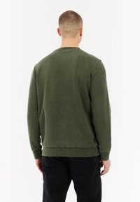 Groene katoenen sweatshirt met lange mouwen, ronde halslijn en een effen textuur. Heeft een licht gebogen zoom en een subtiele merkdetailing aan de onderkant.