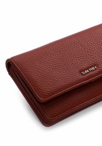 Brown textured leather wallet with a fold-over design, featuring a silver logo accent. Compact shape with visible stitching.