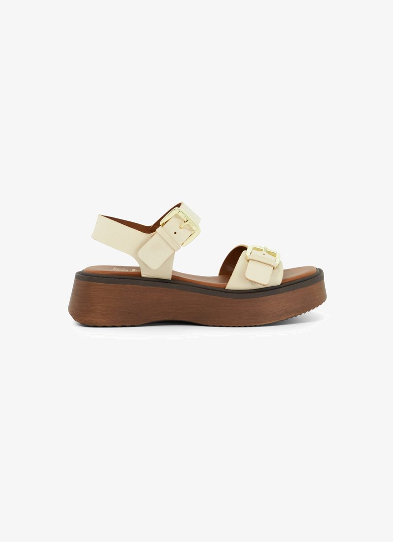 Platform sandals with a cream synthetic upper, two square buckles, and a light brown wooden-like wedge sole for added height.