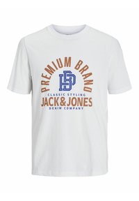 Biela bavlnená tričko s krátkymi rukávmi, na ktorom je grafický dizajn v modrom a hnedom texte s nápisom "PREMIUM BRAND JACK & JONES."