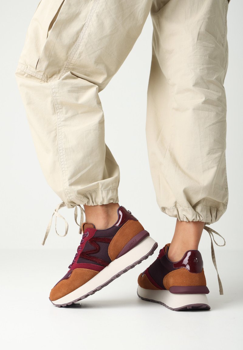 Multicolor sneakers met bordeauxrood gaas, suède accenten in bruin en een witte tussenzool. Ronde neus en gestructureerde rubberen buitenzool.