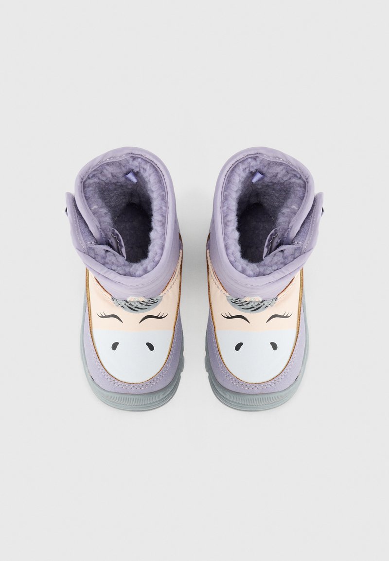 Botas moradas con un diseño de dibujo animado que presenta una cara, interior suave, suelas de goma y un detalle en contraste a lo largo de los bordes.