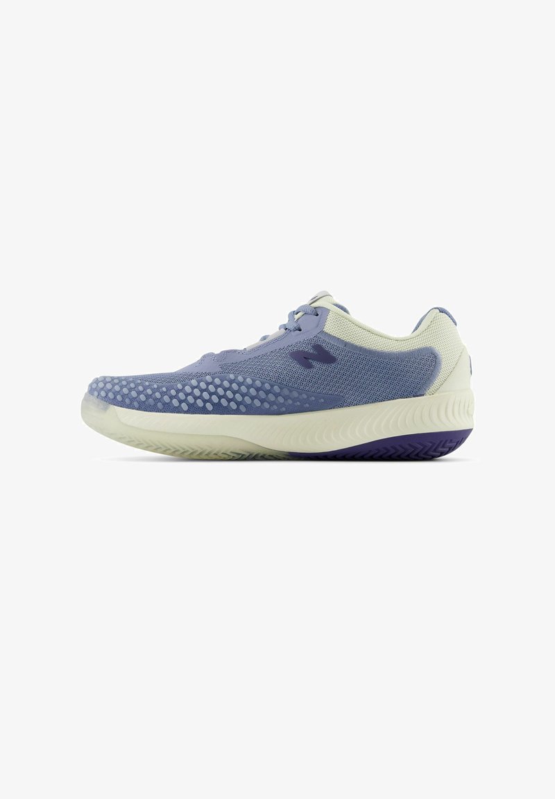 Baskets de sport violet clair avec une matière en mesh et des découpes circulaires, accents blancs sur le talon et la languette, et une semelle texturée avec des détails violets.