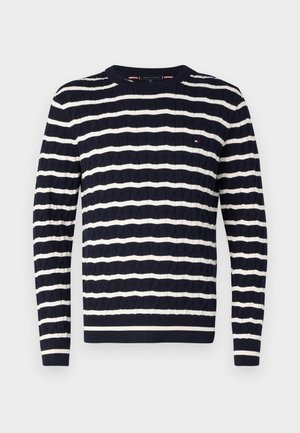 Mornarsko plavi džemper s bijelim horizontalnim prugama, teksturiranim dizajnom od cable knit, okruglim izrezom i rebrastim manžetama i rubom. Uključena mala oznaka s logotipom.