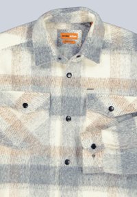 Karierte Hemd in Grau, Beige und Weiß aus Wollmischung; mit Druckknöpfen, zwei Fronttaschen und klassischem Kragen. Reguläre Passform.