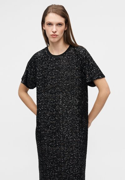Μαύρο φόρεμα με κοντά μανίκια από υφασμάτινη υφή με λαμπερό φινίρισμα. Διαθέτει στρογγυλή λαιμόκοψη και άνετη, φαρδιά γραμμή.
