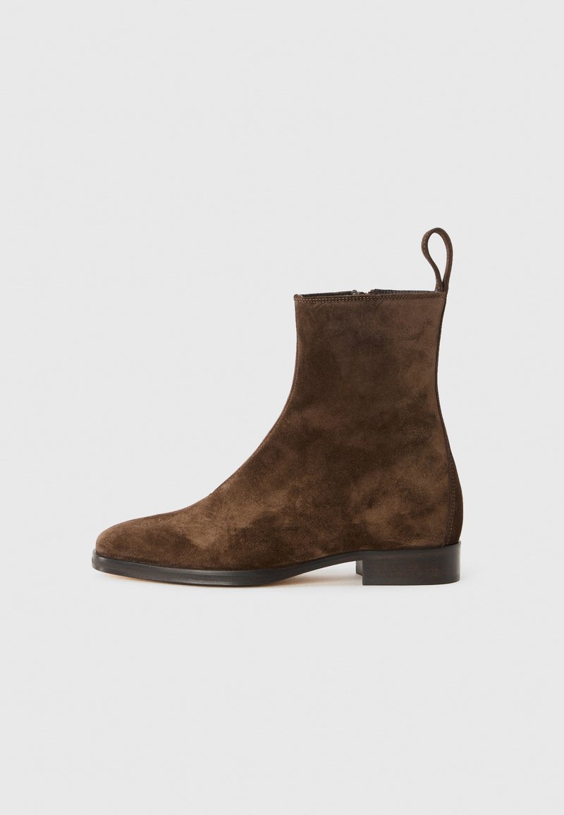 Bruna mockalädersankelboots med en slät finish, rund tå och en liten klack. Har en dragflik bak för enkel påtagning.