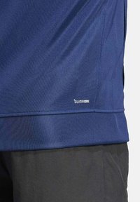 Maglietta atletica blu navy con branding ClimaCool, realizzata in tessuto liscio e traspirante. Presenta un design aderente e dettagli di cuciture a contrasto.