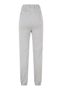 Pantalon de survêtement gris avec une taille élastique, des jambes fuselées et des poignets élastiques ; fabriqué en matériau doux et léger avec une texture lisse.