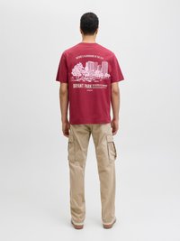 Maroon pamuk majica s bijelim grafičkim prikazom Bryant Parka. Uparena s kašmir hlačama s bočnim džepovima, opuštenog kroja i s manžetama.