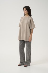Oversized beige cotton t-shirt with short sleeves, paired with gray patterned wide-leg pants featuring subtle metallic accents.