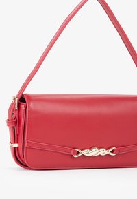 Borsa a tracolla in finta pelle rossa con accento in catena dorata, forma rettangolare, tracolla singola e superficie liscia.