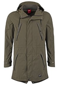 Parka impermeabile verde oliva con cappuccio, zip frontale, due tasche laterali e dettagli con cordoncino. Presenta una texture liscia e un tessuto leggero.