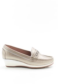 Mocassini beige metallici con dettagli perforati sulla tomaia, tacco a zeppa e superficie in pelle liscia. Accenti bianchi sulla suola.