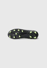 Suela de bota de fútbol negra con goma texturizada, tacos triangulares verdes para tracción, y un diseño en espiral distintivo en el centro.