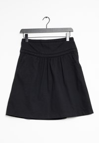 Jupe noire en tissu texturé, dotée d'une taille élastique, d'un design plissé et d'une forme évasée, suspendue à un cintre noir.