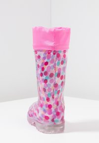 Botte de pluie en caoutchouc transparente avec un revers en satin rose, ornée d'un motif de points multicolores en rose, bleu et violet. Semelle texturée pour l'adhérence.