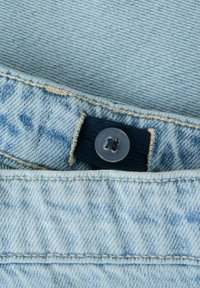 Pulsante regolabile con cintura in denim blu chiaro e fascia elastica interna per la vestibilità della taglia.