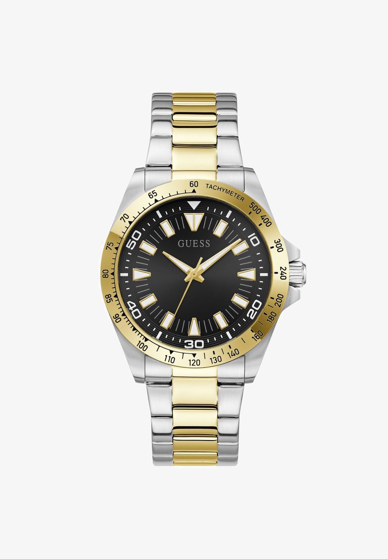 Ανδρικό ρολόι Guess με μαύρο καντράν, χρυσό-ασημένιο μεταλλικό λουράκι, χρυσή στεφάνη με ταχύμετρο και χρυσούς δείκτες και σημεία ωρών.