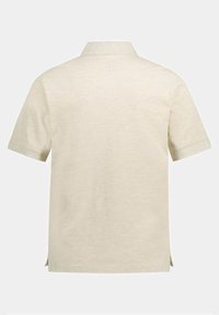 Polo shirt beige a maniche corte con colletto, realizzato in tessuto morbido, con fessure laterali all'orlo per facilitare il movimento. Texture liscia.