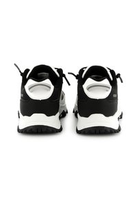 Scarpe sportive in bianco e nero con tomaia testurizzata, tallone rinforzato e suola robusta. Accenti riflettenti e linguette sul tallone.