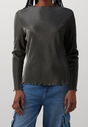 Top a maniche lunghe grigio scuro con texture a costine, caratterizzato da un collo rotondo e una silhouette aderente. Abbinato a jeans blu.