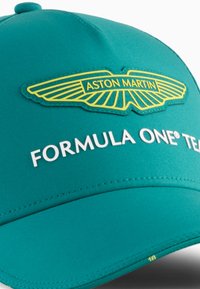 Gorra del equipo Aston Martin Formula One® en tela color teal, con un logo amarillo y texto blanco. Diseño estructurado con visera curvada y detalles de costura.