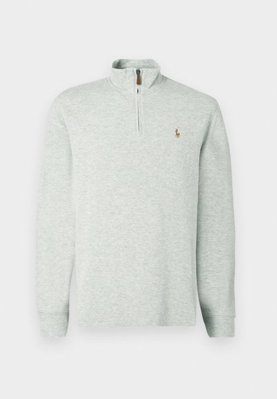 Ανοιχτό γκρι πουλόβερ με φερμουάρ ενός τέταρτου, μακριά μανίκια και ραμμένες μανσέτες. Διαθέτει ένα μικρό κεντημένο λογότυπο στην αριστερή πλευρά του στήθους. Μαλακό πλεκτό υλικό.