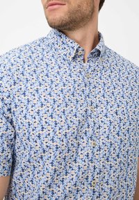 Korte mouw button-up shirt met een blauw en beige cirkelpatroon op een lichte achtergrond, een klassieke kraag en twee knopen aan de voorkant.
