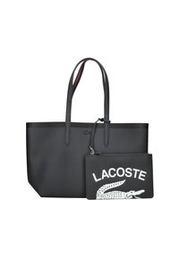 Bolsa tote negra con textura suave, dos asas largas y un bolsillo negro desmontable que presenta el texto y logotipo en blanco de "LACOSTE".