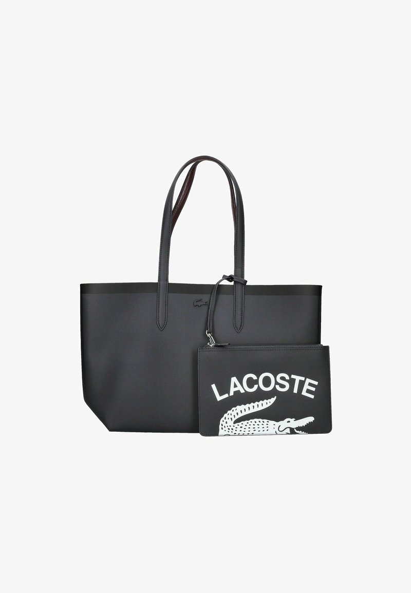 Bolsa tote negra con textura suave, dos asas largas y un bolsillo negro desmontable que presenta el texto y logotipo en blanco de "LACOSTE".