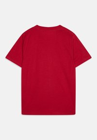 T-shirt rossa in cotone con maniche corte, scollo a giro e una texture liscia. Nessun motivo o grafica, presenta un design semplice e classico.