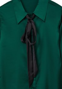 Blusa di raso verde con grande colletto, dotata di un nastro nero legato al collo. Texture liscia, con una lucentezza che riflette la luce.