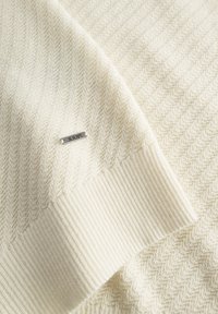 Strickpullover in Off-White mit einem Zickzackmuster. Verfügt über einen gerippten Saum und ein kleines silbernes Etikett mit der Prägung "JOOP!".