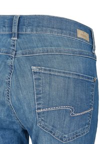 Jean en denim bleu à coupe droite. Présente une poche arrière avec une couture incurvée distinctive et une étiquette de marque sur la taille.