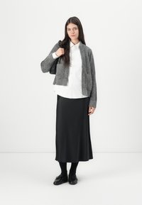 Gray knitted cardigan, white button-up shirt, black satin midi skirt, black loafers, and a black handbag. Smooth textures, minimalist design.
